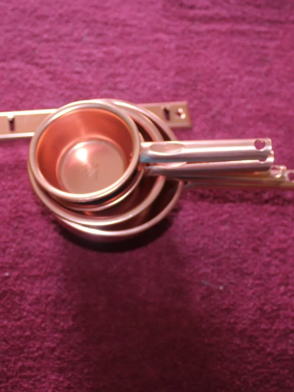 4-piece copper colored metal  measuring cups, complete with a matching hanger